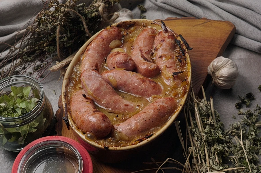 Poolse witte worst (biała kiełbasa) uit de oven met bier, mosterd en ui